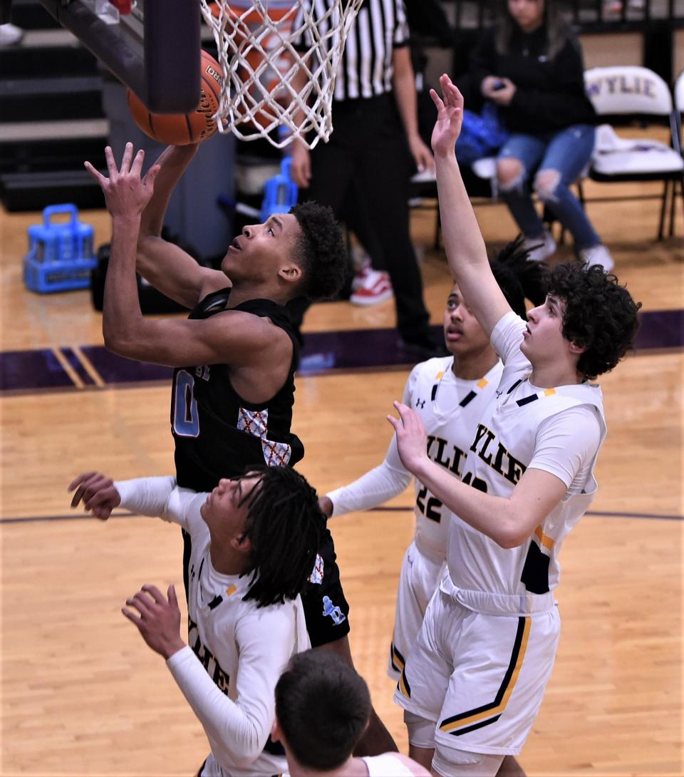 Lubbock Monterey's Kash Lewis grabs a rebound as three Wylie players look on in the first half.