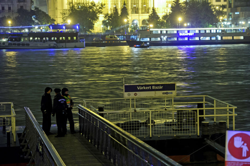 Police officers stand on a landing dock early Thursday, May 30, 2019 after a tourist boat crashed with a river cruise boat in River Danube in Budapest, Hungary, late Wednesday, May 29. The boat capsized and sunk in the river Wednesday evening, with dozens of people on board, including passengers and crew, Hungarian media reported. (Peter Lakatos/MTI via AP)
