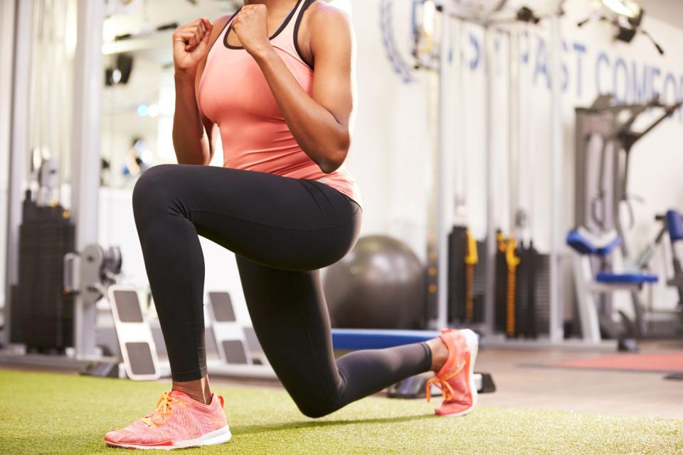 woman doing lunges in a gym, cropped shot