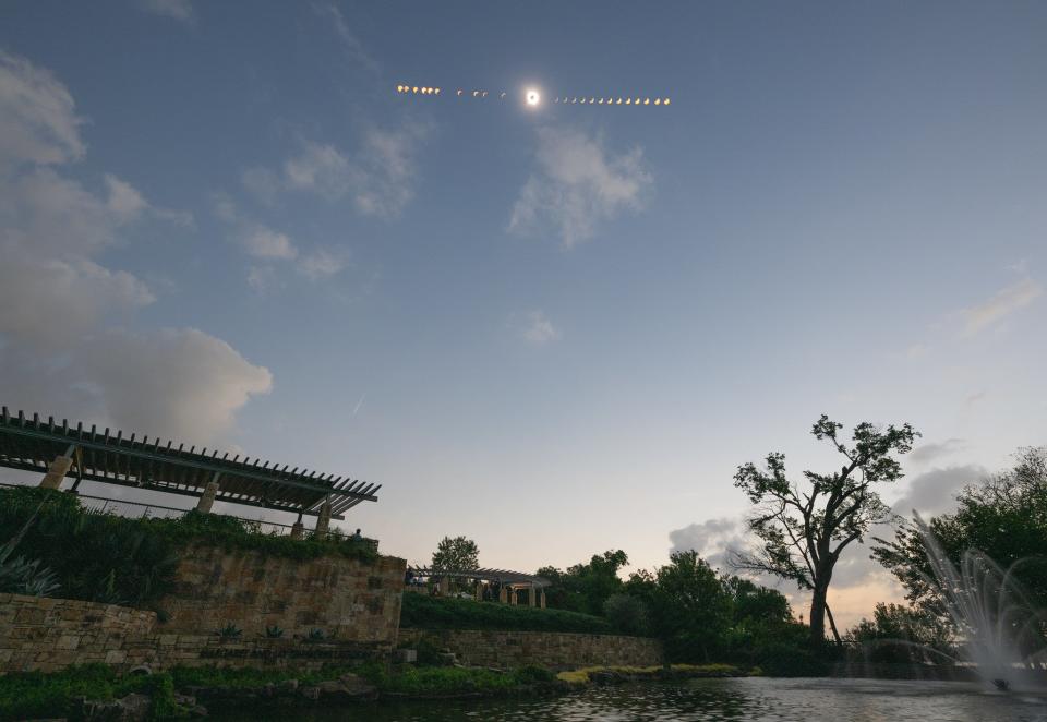 a composite of the eclipse showing all stages above a lake