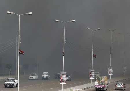 Cars drive through clouds of smoke during a fire at Cairo's International Convention Centre (CICC) in Nasr City district March 4, 2015. REUTERS/Amr Abdallah Dalsh