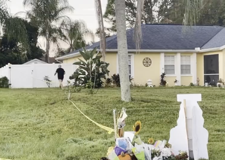 Chris Laundrie carries off a protest sign that had been planted in his lawn in North Port, Florida (Fox News)