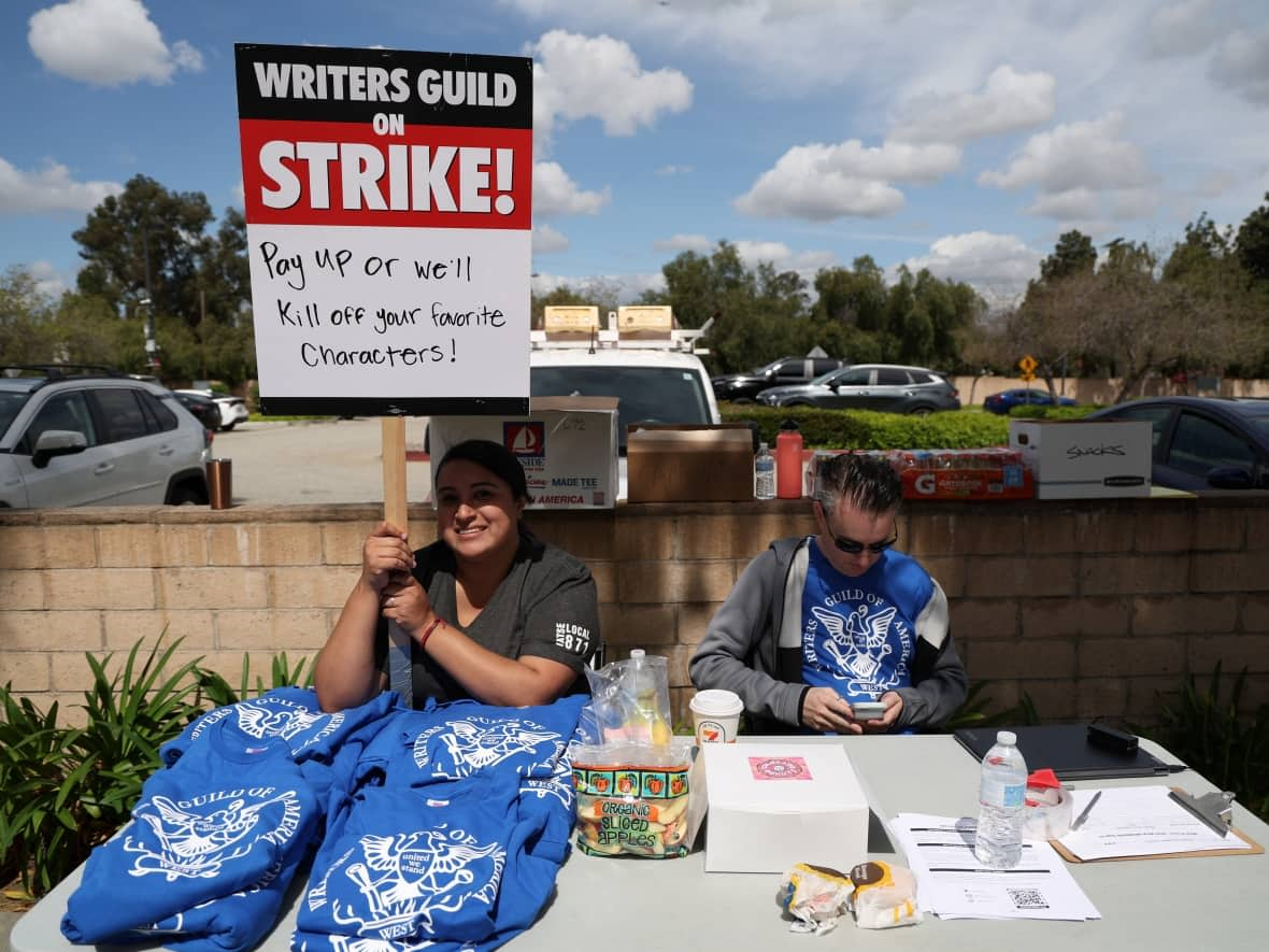 Workers and supporters of the Writers Guild of America protest outside Universal Studios Hollywood after union negotiators called a strike for film and television writers, in the Universal City area of Los Angeles on May 3, 2023. (Mario Anzuoni/Reuters - image credit)