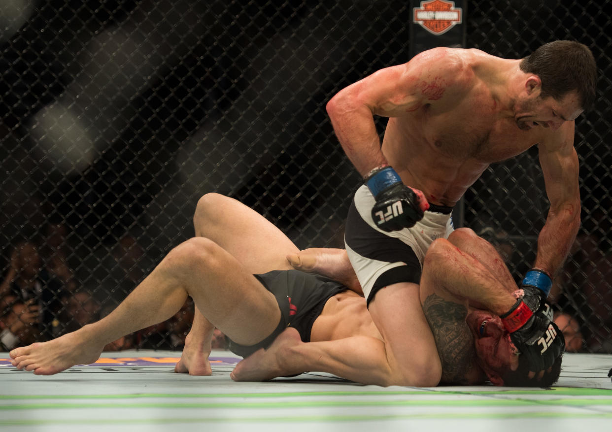 LAS VEGAS, NV - DECEMBER 12: Luke Rockhold (top) punches Chris Weidman in their middleweight title fight during the UFC 194 event inside MGM Grand Garden Arena on December 12, 2015 in Las Vegas, Nevada.  (Photo by Brandon Magnus/Zuffa LLC/Zuffa LLC via Getty Images)