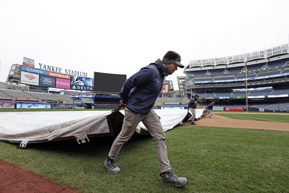 A member of the grounds crew covers the field before the New York Yankees baseball workout on Thursday, April 7, 2022, in New York. The Yankees will face the Boston Red Sox on Friday. (AP Photo/Adam Hunger)