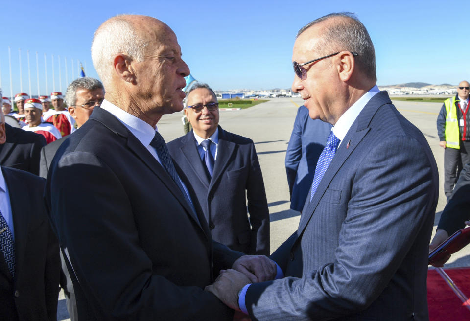 Turkey's President Recep Tayyip Erdogan, right, shake hands with Tunisian President Kais Saied, at the airport, in Tunis, Tunisia, Wednesday, Dec. 25, 2019. Erdogan with top Turkish officials is on an unannounced visit to Tunisia to meet Saied. (Slim Abid/Tunisian Presidency via AP)