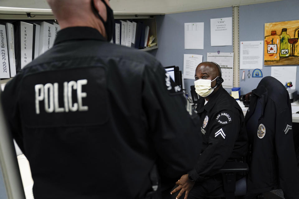 In this Sept. 9, 2020, photo Los Angeles Police recruitment officers, Dion Gourdine, right, and Christopher Hoffman, chat in the office in Los Angeles. (AP Photo/Jae C. Hong)