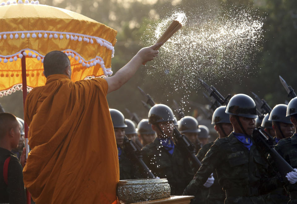 A Buddhist monk splashes holy water to Thai soldiers during the Royal Thai Armed Forces Day ceremony at a military base in Bangkok, Thailand, Friday, Jan. 18, 2019. (AP Photo/Sakchai Lalit)