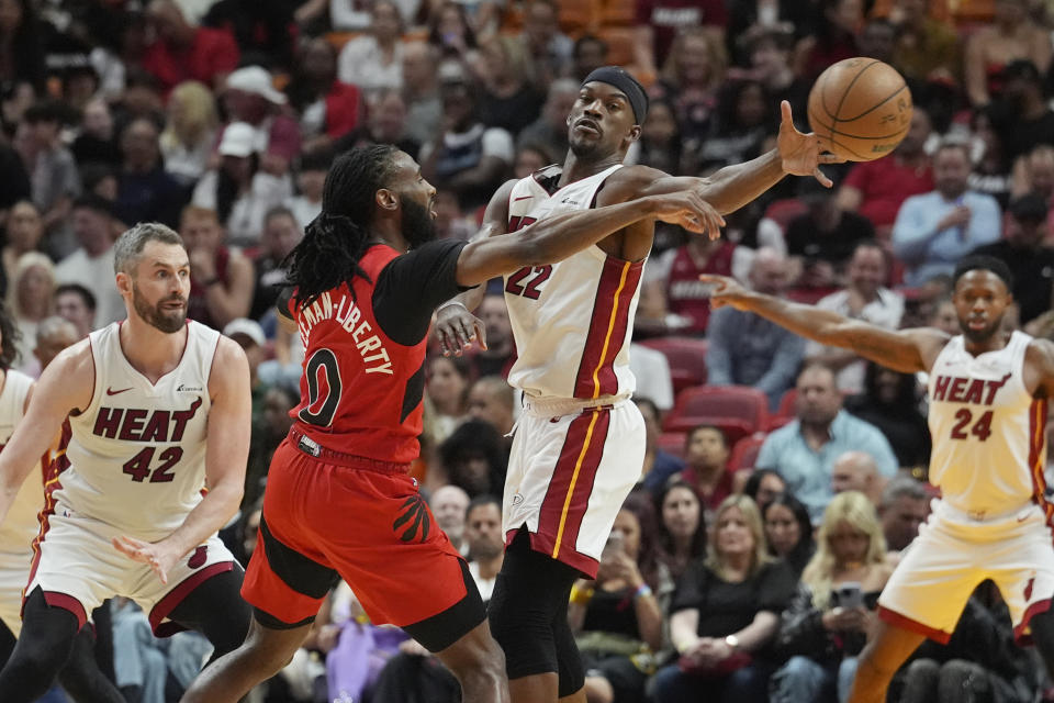Miami Heat forward Jimmy Butler (22) blocks a pass by Toronto Raptors guard Javon Freeman-Liberty (0) during the first half of an NBA basketball game, Friday, April 12, 2024, in Miami. (AP Photo/Marta Lavandier)