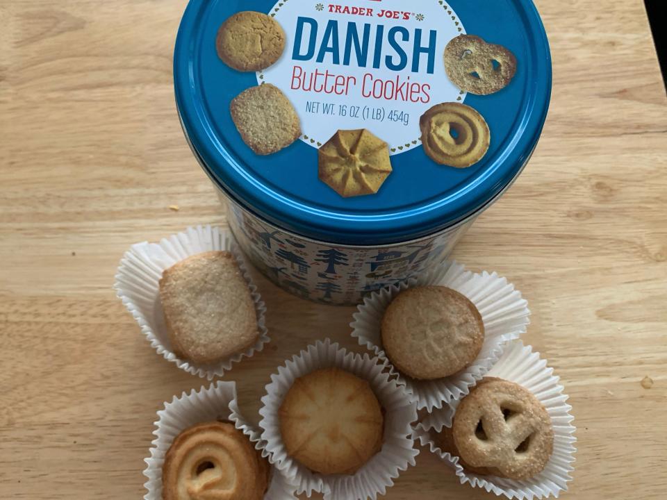 blue tin of trader joe's danish butter cookies with cookies in paper cups on wooden table