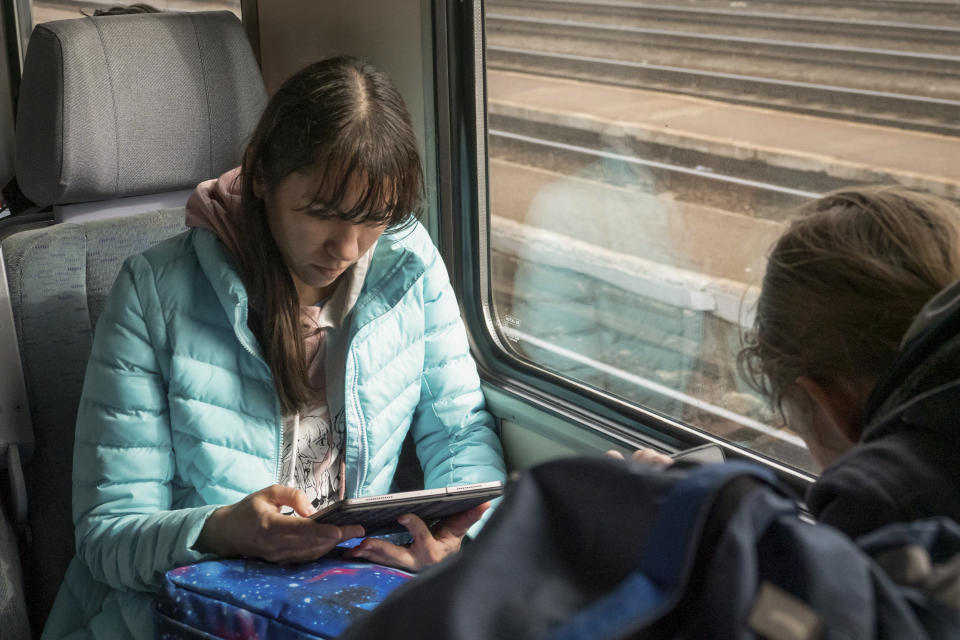 Olena, a Russian citizen fleeing from Kyiv, Ukraine (no family name given for safety resson) sits on a train while traveling from the Hungarian - Ukrainian border towards Budapest on Thursday, March. 3, 2022. Olena who years ago left her home country in opposition to Vladimir Putin's government has been forced to flee again — this time from her adopted home of Kyiv — as Putin's armed forces assault Ukraine. (AP Photo/Balazs Kaufmann)