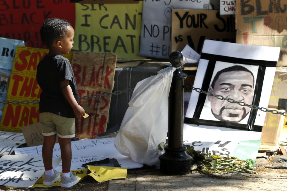 Kyrie Harris, 2, looks at a drawing of George Floyd at a Juneteenth rally in Sacramento, Calif., Friday, June 19, 2020. Juneteenth marks the day in 1865 when federal troops arrived in Galveston, Texas, to take control of the state and ensure all enslaved people be freed, more than two years after the Emancipation Proclamation. (AP Photo/Rich Pedroncelli)
