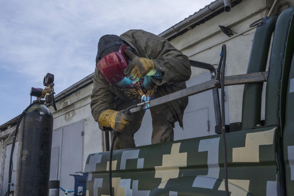 Car welder Ostap Datsenko, 31, works on a donated pickup truck so a volunteer can drive it to frontlines, at a welding workshop in Lviv, western Ukraine, Sunday, March 27, 2022. Datsenko says he was ready like all Ukrainian men to be called up to fight. But he had no combat experience, meaning his time was yet to come. Until then, he said, “I’m doing what I can.” (AP Photo/Nariman El-Mofty)