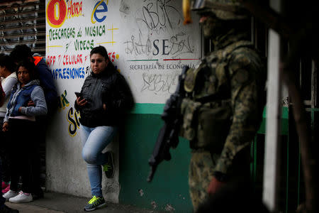 FILE PHOTO: Residents stand near a Mexican marine soldier as he guards an area after a shootout between gang members and the Mexican army in Mexico City, Mexico July 20, 2017. REUTERS/Carlos Jasso/File Photo