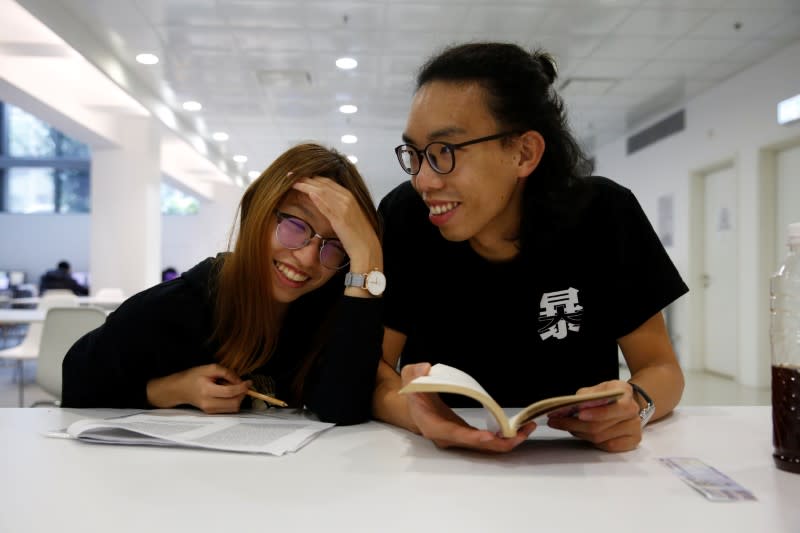 Derek Tai and his girlfriend Ann react inside a library at Chinese University of Hong Kong in Hong Kong