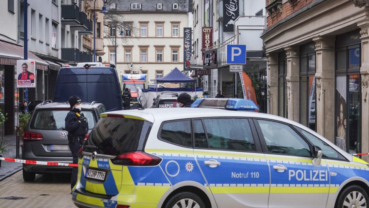 Von Polizeifahrzeugen und der Spurensicherung abgeschirmt ist der Tatort in der Innenstadt von Wiesbaden.