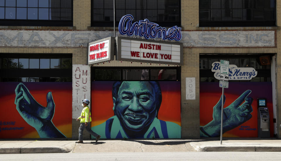 A worker passes a nightclub that remains boarded and closed in Austin, Texas, Monday, May 18, 2020. Texas continues to go through phases as the state reopens after closing many non-essential businesses to help battle the spread of COVID-19. (AP Photo/Eric Gay)