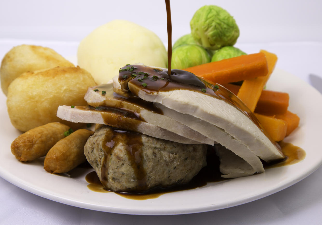 Traditional British Christmas dinner  turkey mashed potatoes, sprouts, battened carrots, roast potatoes,ham,stuffing and cocktail sausages with gravy being added 