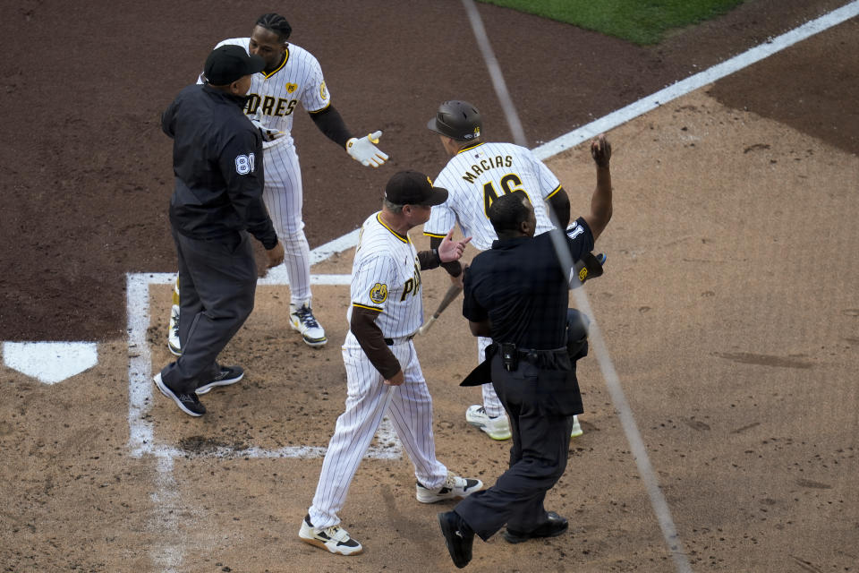 San Diego Padres' Jurickson Profar, above, argues with first base umpire Adrian Johnson, left, as San Diego Padres manager Mike Shildt, below center, is ejected by home plate umpire Ramon De Jesus, right, during the second inning of a baseball game against the Toronto Blue Jays, Saturday, April 20, 2024, in San Diego. Both Profar and Shildt were ejected. (AP Photo/Gregory Bull)