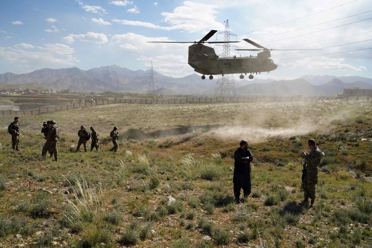 A US military Chinook helicopter lands on a field outside the governor's palace during a visit by the commander of US and NATO forces in Afghanistan, in Maidan Shar, capital of Wardak province: AFP via Getty Images