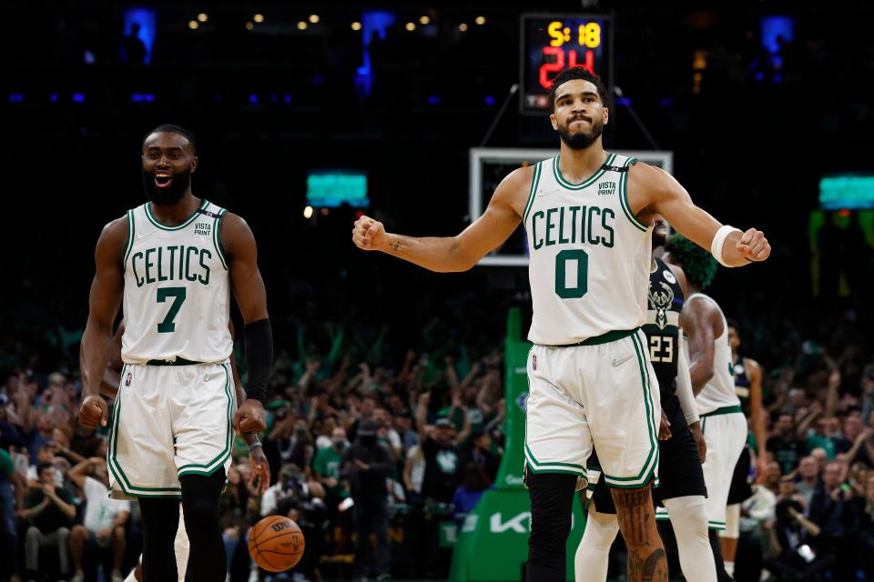 Celtics guard Jaylen Brown, left,and forward Jayson Tatum celebrate as they wrap up their Eastern Conference semifinal series against the Bucks.