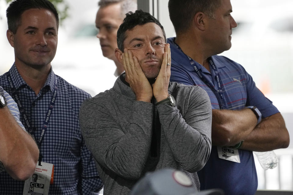 Rory McIlroy, of Northern Ireland, center, listens to PGA Tour Commissioner Jay Monahan during a press conference at East Lake Golf Club prior to the start of the Tour Championship golf tournament Wednesday Aug 24, 2022, in Atlanta, Ga. (AP Photo/Steve Helber)