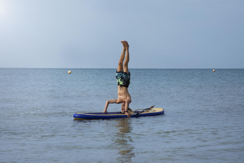 Believe it or not, stand-up paddle boarding and yoga are the perfect partners. Your board acts like your mat and it works your core even more than regular yoga because you’re balancing on water. And if you fall in? You probably wanted to cool off, right? In the calm water of Hove Lagoon, near Brighton, <a href="https://www.lagoon.co.uk/" rel="nofollow noopener" target="_blank" data-ylk="slk:Lagoon Watersports;elm:context_link;itc:0;sec:content-canvas" class="link ">Lagoon Watersports</a> offers all kinds of outdoor activities, including SUP Yoga lessons. Tethered to a buoy, you’ll practice everything from downward-facing dog to seated twists while balancing on your board. Travel time: 1 hour (train from Victoria to Hove) <em>[Photo: Getty]</em>