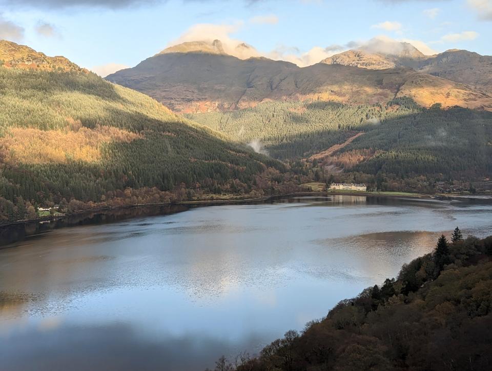 view out of train window in scotland, water in foreground and mountains in the back