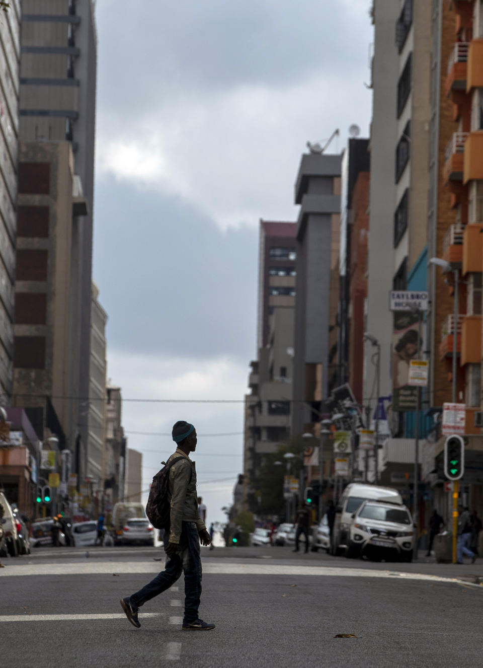 A man walks on the street in downtown Johannesburg, South Africa, Thursday, April 9, 2020. South Africa and more than half of Africa's 54 countries have imposed lockdowns, curfews, travel bans or other restrictions to try to contain the spread of COVID-19. The new coronavirus causes mild or moderate symptoms for most people, but for some, especially older adults and people with existing health problems, it can cause more severe illness or death. (AP Photo/Themba Hadebe)