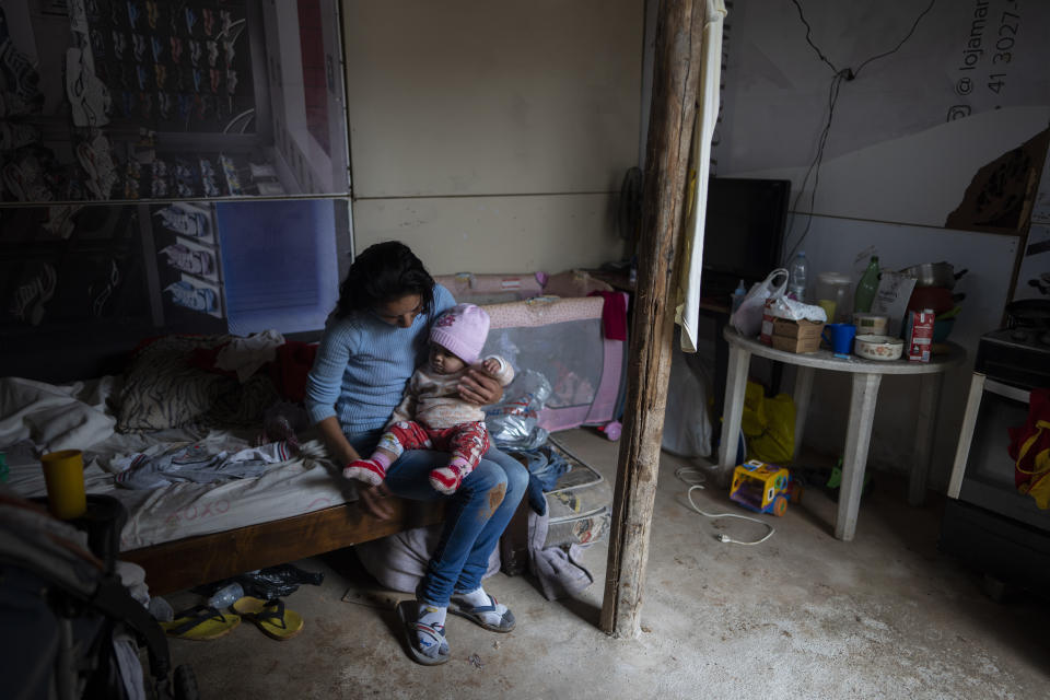 Erika Correia dos Santos, 23, changes the clothing of her 7-month-old daughter Sara inside their shack in Brasiliandia, one of Sao Paulo's poorest neighborhoods, in Brazil, Thursday, Sept. 29, 2022. Correia dos Santos is unemployed and relies on a government handout but that is not enough and they regularly go hungry. Thirty-three million people experience hunger as the country heads into the Oct. 2nd general elections. (AP Photo/Victor R. Caivano)