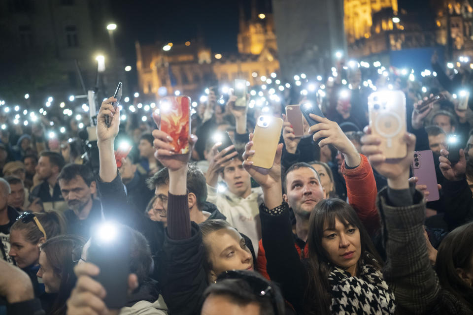 People listen to the speech of former Hungarian government insider Peter Magyar next to Kossuth Square on Tuesdy, in Budapest, Hungary, March 26, 2024. Magyar on Tuesday released a recording that he claims proves senior officials in the government of Prime Minister Viktor Orban manipulated court documents to cover up their involvement in a corruption case. (AP Photo/Denes Erdos)