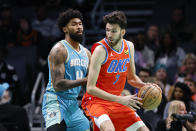 Oklahoma City Thunder forward Chet Holmgren (7) looks to drive against Charlotte Hornets center Nick Richards, left, during the first half of an NBA basketball game in Charlotte, N.C., Sunday, April 7, 2024. (AP Photo/Nell Redmond)