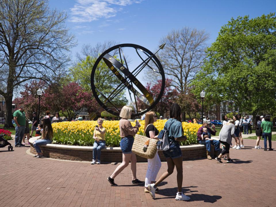 People walk past blooming tulips in Central Park in downtown Pella, Iowa on May 3, 2020.  (Jack Kurtz/ZUMA Wire)