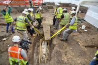 A team lifts the heavy lid of the stone coffin in Leicester.