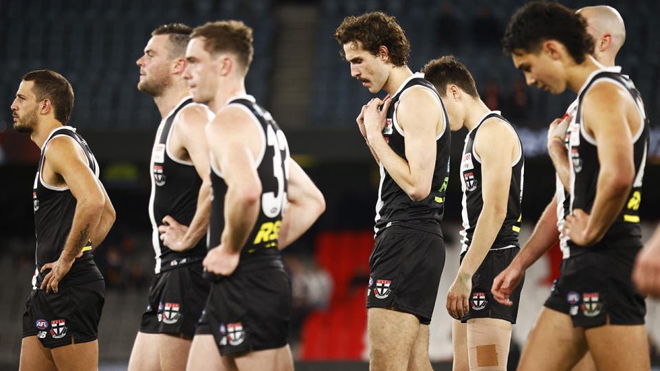 St Kilda players look dejected as they walk from the field after their AFL loss to Brisbane.