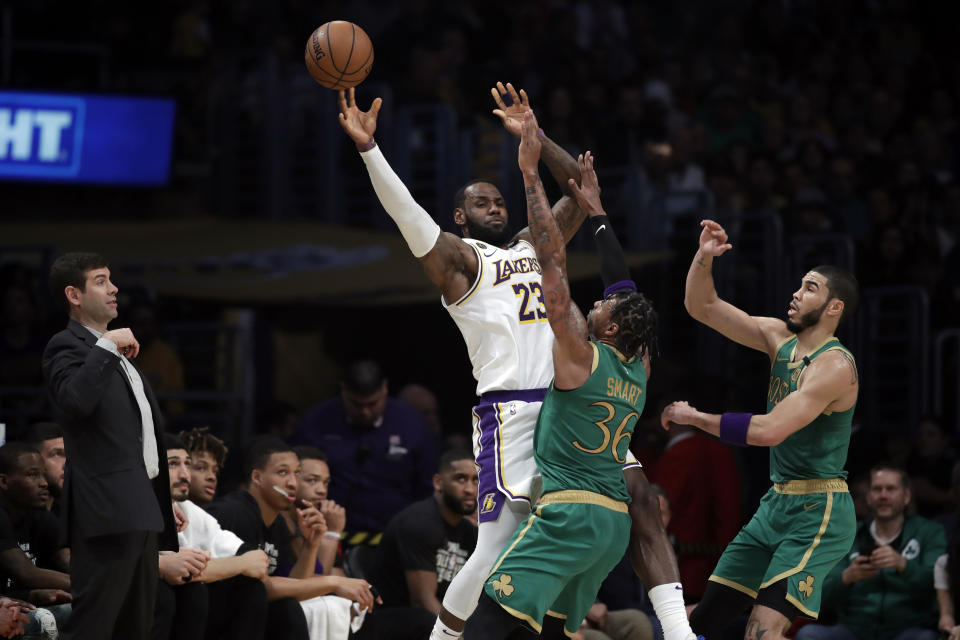 Los Angeles Lakers' LeBron James (23) is defended by Boston Celtics' Marcus Smart (36) and Jayson Tatum during the first half of an NBA basketball game Sunday, Feb. 23, 2020, in Los Angeles. (AP Photo/Marcio Jose Sanchez)