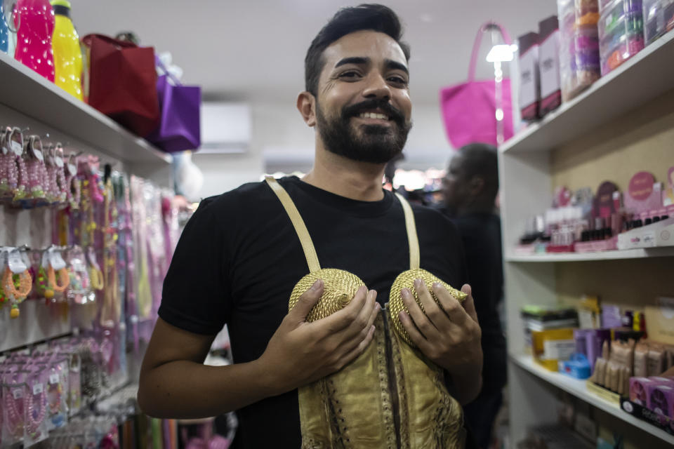 Vitoriano Valmir juega con un disfraz de Madonna a la venta en una tienda en Río de Janeiro, Brasil, el jueves 2 de mayo de 2024. Valmir dijo que iría al concierto de Madonna en la playa de Copacabana el sábado. (Foto AP/Bruna Prado)