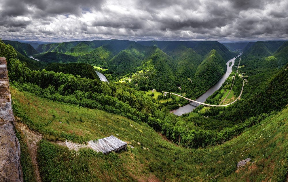 A view over the lush green mountainous Susquehanna river valley in Pennsylvania, under a dramatic clouded sky.