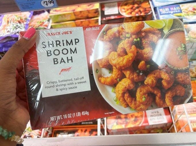 Woman holding a box of Trader Joe's shrimp boom bah