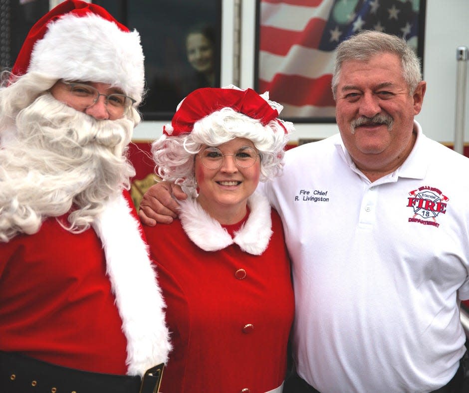 Mills River Fire Chief Rick Livingston poses with Santa and Mrs. Claus.