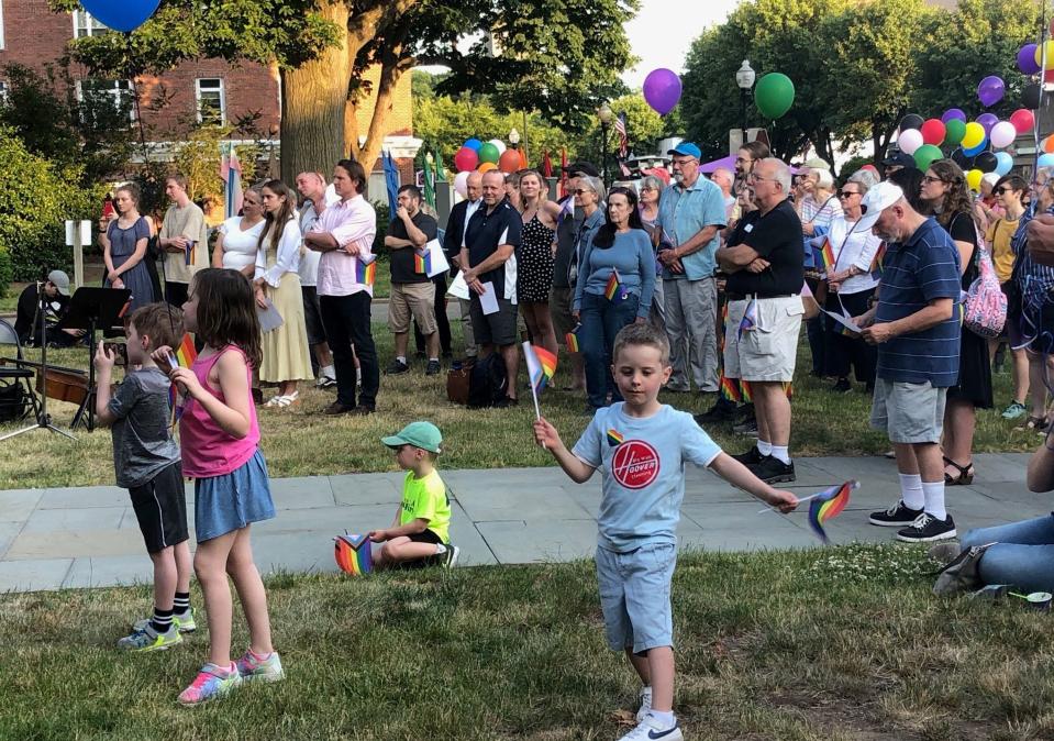 A child waves LGBTQ+ Pride flags while listening to a musical performance during the Witness for Love event at the Church of the Redeemer in Morristown Thursday, June 1, 2023.
