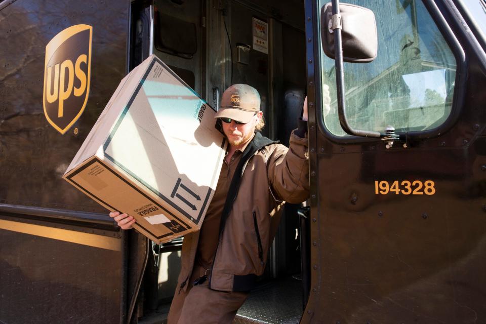 Chance Futrell carries a package out of his UPS truck while making a delivery in Fulton, Miss., on Wednesday, December 6, 2023. Futrell was accidentally shot by his friend 14 years ago when he was 10 years old and underwent 18 surgeries.