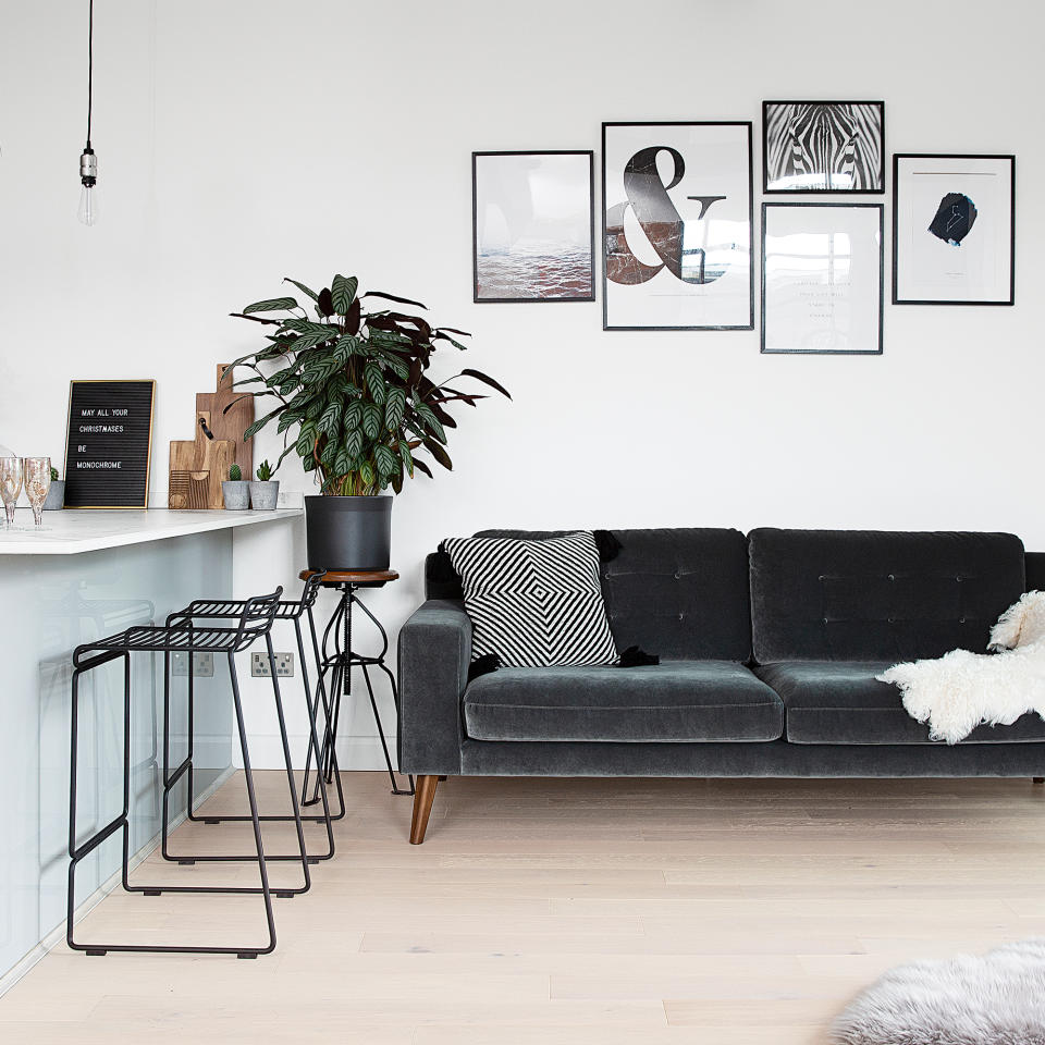 Monochrome kitchen diner with dark grey velvet sofa next to a breakfast bar