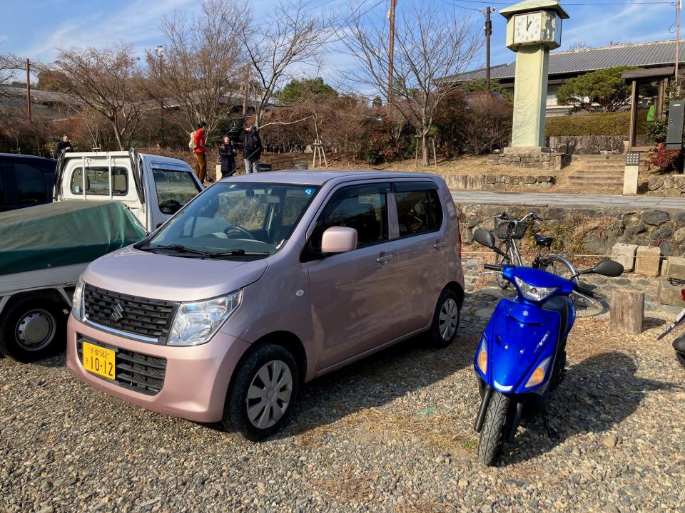 A Suzuki Wagon R parked by a moped in Kyoto