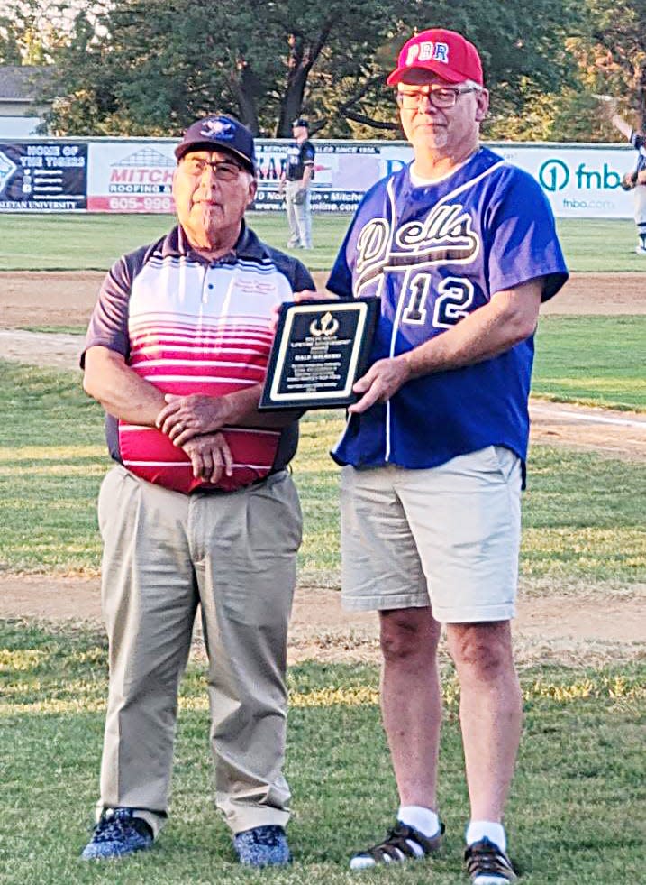 Lily native and 1980 Bristol High School graduate Dale Solberg (right) received the South Dakota Amateur Baseball Association's Ralph Macy Man of the Year Award from SDABA president Dale Weber during the 90th state tournament that concluded recently at Mitchell.