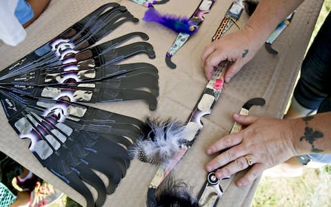 A vendor arranges decorated solar viewing glasses during an arts and crafts fair ahead of a total solar eclipse on the campus of Southern Illinois University - Credit:  Bloomberg