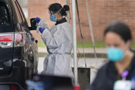 FILE - In this Oct. 21, 2020, file photo, medical personnel prepare to administer a COVID-19 swab at a drive-through testing site in Lawrence, N.Y. The United States is approaching a record for the number of new daily coronavirus cases in the latest ominous sign about the disease's grip on the nation. (AP Photo/Seth Wenig, File)