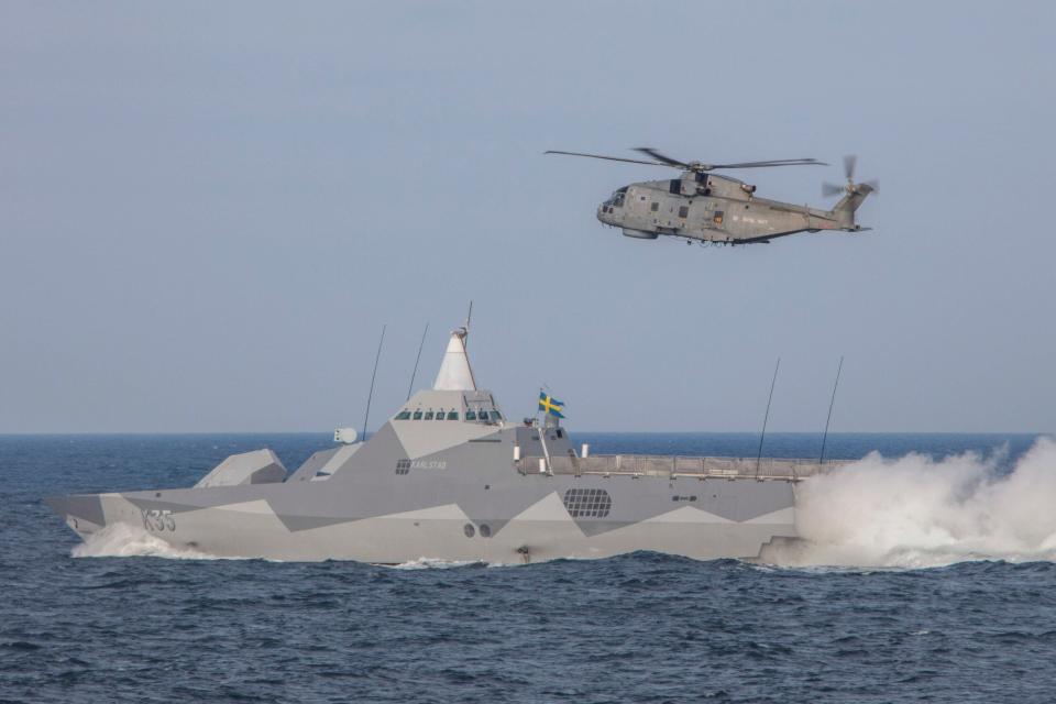 Swedish <em>Visbly</em> class corvette HSwMS <em>Karlstad</em> and a Royal Navy Merlin helicopter take part in a surface exercise with partnering NATO warships whilst participating in BALTOPS 20, June 12, 2020. <em>Dan Rosenbaum/MOD</em>
