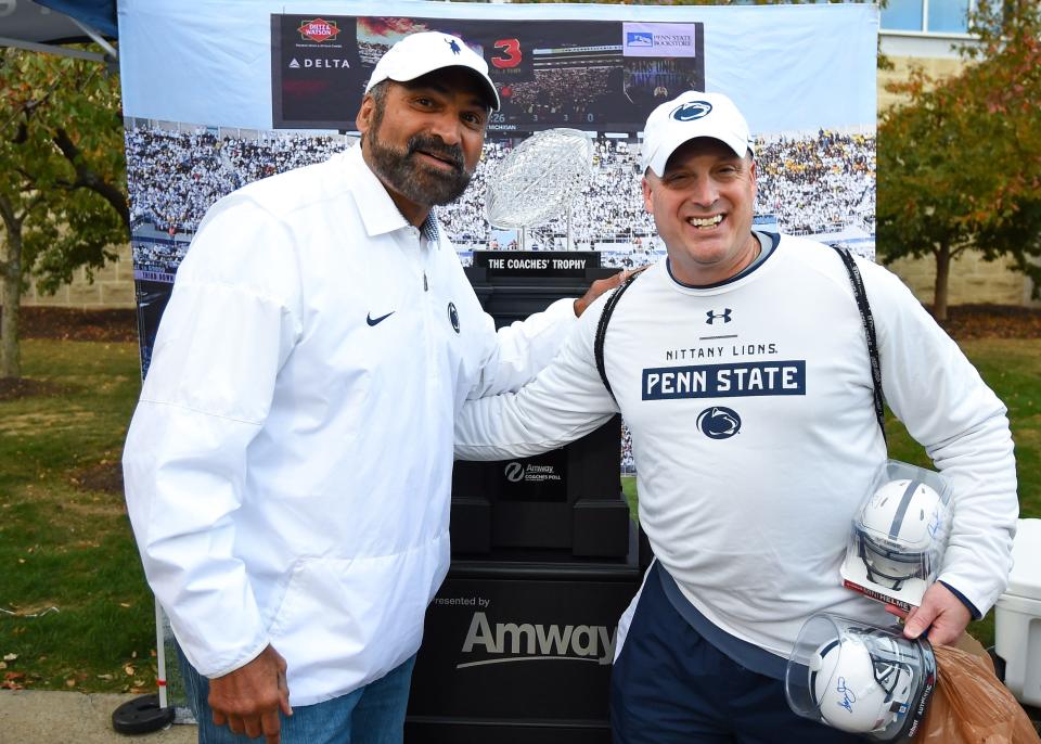 Oct 19, 2019; University Park, PA, USA; Penn State Nittany Lions alum Franco Harris poses for a photo with a fan with the Amway coaches poll National Championship trophy prior to the game between the Michigan Wolverines and the Penn State Nittany Lions at Beaver Stadium. Mandatory Credit: Rich Barnes-USA TODAY Sports