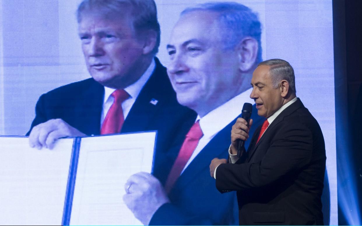 Israeli Prime Minister, Benjamin Netanyahu displays a photograph of himself and US President Donald Trump at a campaign rally ahead of the Israeli election - Getty Images Europe